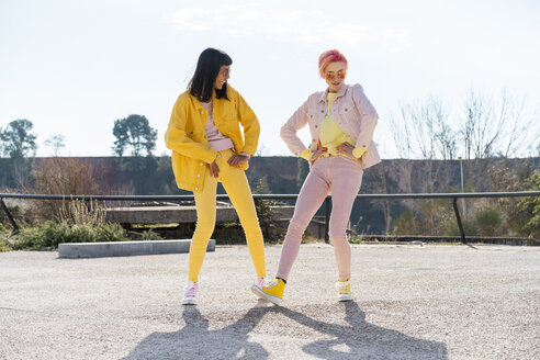 two alternative friends having fun, wearing yellow and rosa jeans clothes - AFVF01026