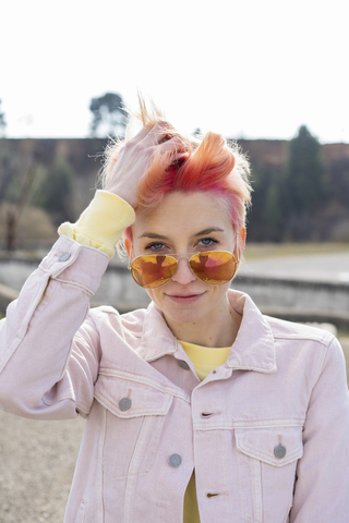 Portrait of young woman, sun glasses and pink jeans jacket stock photo