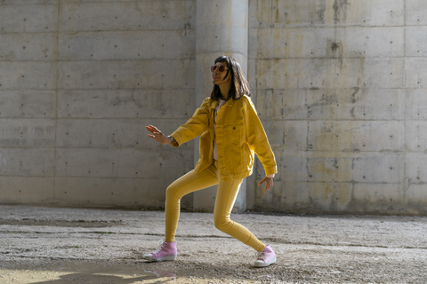 Woman wearing yellow jeans clothes, dancing stock photo