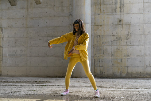 Woman wearing yellow jeans clothes, dancing - AFVF01047
