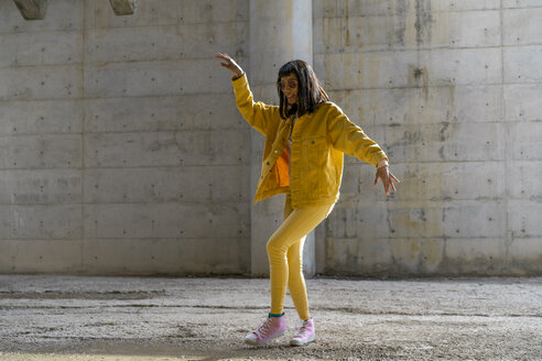 Frau in gelber Jeanskleidung, tanzend - AFVF01048