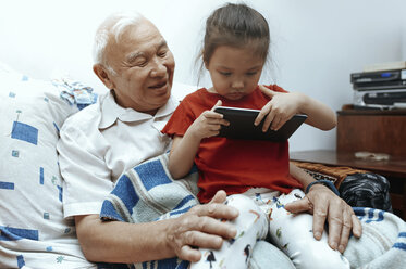 Großvater und Enkelin mit digitalem Tablet zu Hause - AZF00055