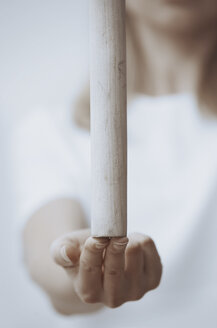 Frau übt Wushu und balanciert Holzstab auf Fingerspitzen, Nahaufnahme - AZF00065