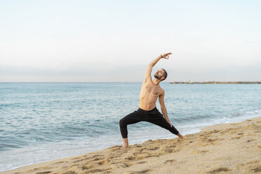 Spanien: Mann beim abendlichen Yoga am Strand - AFVF01074