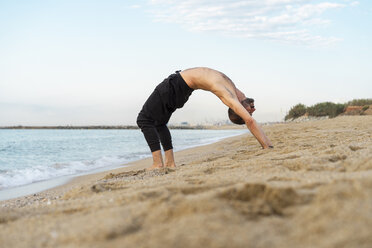 Spanien: Mann macht abends am Strand Yoga, Verbeugung nach oben - AFVF01082