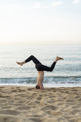 Spanien: Mann beim abendlichen Yoga am Strand - AFVF01085