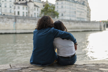 Frankreich, Paris, Rückansicht eines jungen Paares, das auf einer Mauer am Fluss Seine sitzt - AFVF01110