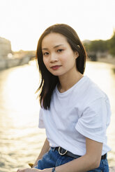 Frankreich, Paris, Porträt einer jungen Frau am Fluss Seine bei Sonnenuntergang - AFVF01124