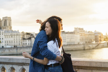 France, Paris, happy young couple hugging at river Seine at sunset - AFVF01128