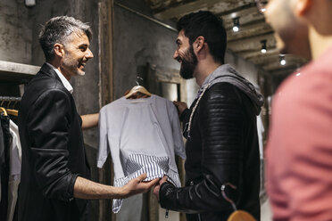 Designer in modernem Herrenbekleidungsgeschäft bietet neue Kollektion für Männer an - JRFF01702