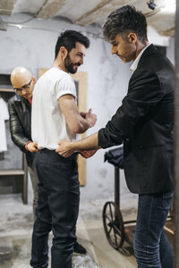 Zwei Männer arbeiten an einem neuen stilvollen Look für einen gut aussehenden Mann im Ausstellungsraum - JRFF01703