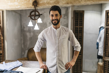 Portrait of smiling man wearing shirt in menswear shop - JRFF01708