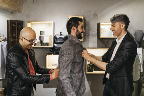 Zwei Männer arbeiten an einem neuen stilvollen Look für einen gut aussehenden Mann im Ausstellungsraum - JRFF01709