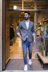 Confident man wearing jacket leaving menswear shop - JRFF01711