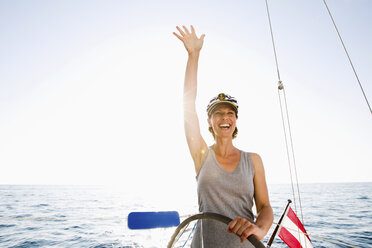 Lächelnde Frau am Steuer eines Bootes - ISF17385