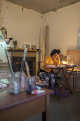 Smiling woman reading at desk - ISF17439