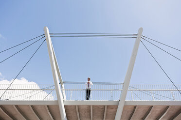 Geschäftsmann auf städtischer Brücke stehend - ISF17494