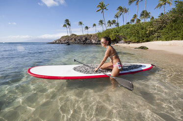 Woman paddleboarding on ocean - ISF17609