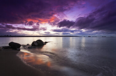 The sunset, an orange and purple sky, reflected in calm water. - MINF02881