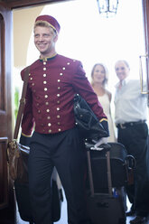 Bellhop carrying luggage in hotel - ISF17680