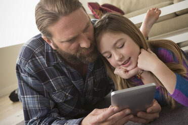 Vater und Tochter betrachten ein digitales Tablet - ISF17734