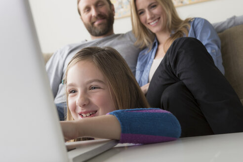 Eltern beobachten ihr Kind bei der Benutzung eines Laptops - ISF17738