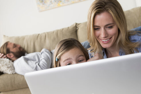Mutter und Tochter schauen auf den Laptop - ISF17739