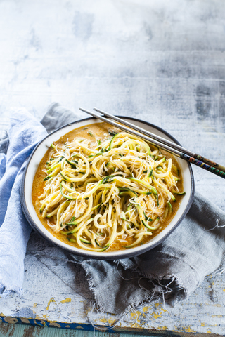 Asian style noodle soup with glas noodles and zoodles in red curry broth stock photo