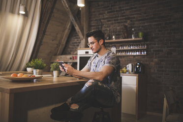 Young man using tablet in kitchen at home - AWF00124