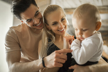 Happy young parents spending time at home with their baby girl - AWF00143