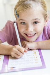 Porträt eines lächelnden kleinen Mädchens, das das Alphabet schreibt - JFEF00891