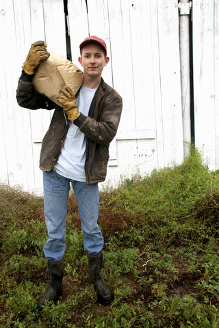 Landwirt mit Futtersack auf der Schulter, lizenzfreies Stockfoto