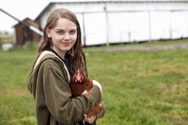 Girl carrying hen - ISF17837