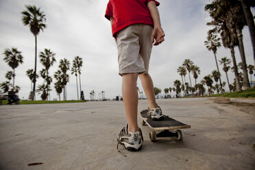Boy riding on skateboard in park - ISF17879