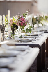 Ein festlich gedeckter Hochzeitsfrühstückstisch mit frischen Blumen in der Mitte. - MINF02946