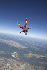 Woman skydiving over rural landscape - ISF17914