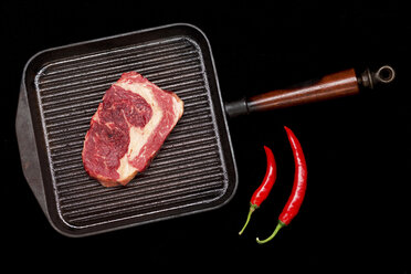 Meat in grill pan with chili peppers - ISF17939