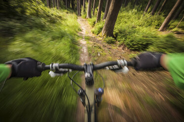 Mountainbiker rast den Waldweg hinunter - ISF18043