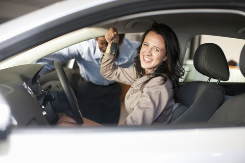 Frau kauft neues Auto vom Verkäufer, lizenzfreies Stockfoto