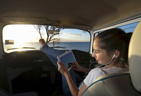 Junge Frau im Wohnmobil mit digitalem Tablet - ISF18129