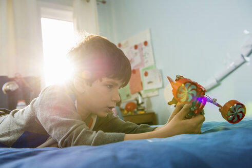 Junge auf Bett liegend mit Spielzeug - ISF18145