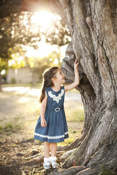 Porträt eines Mädchens, das einen Baumstamm berührt - ISF18275