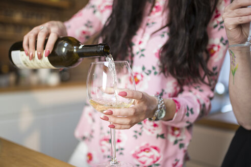 Nahaufnahme einer Frau, die Weißwein in ein Glas gießt - AWF00147
