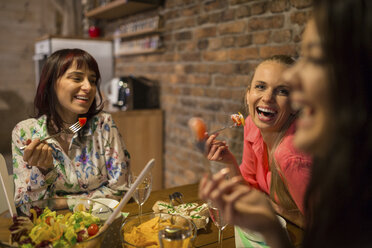 Glückliche Freundinnen beim gemeinsamen Abendessen zu Hause - AWF00164