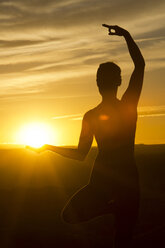 Junge Frau beim Yoga im Sonnenlicht, Moab, Utah, USA - ISF18450