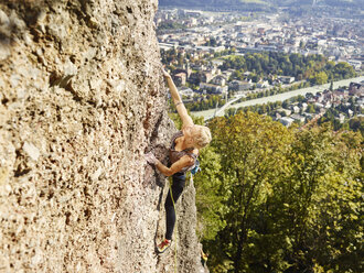 Österreich, Innsbruck, Steinbruch Hoettingen, Frau klettert in Felswand - CVF01014