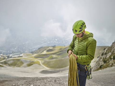 Österreich, Innsbruck, Nordkette, Mann mit Seil und Kletterausrüstung, lizenzfreies Stockfoto