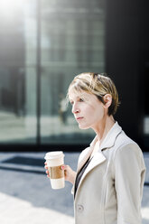 Porträt einer Geschäftsfrau mit Coffee to go - GIOF04025