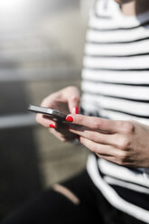 Woman's hands using cell phone, close-up - GIOF04034