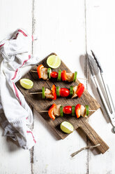 Spieße mit rohem Hähnchen, Tomate, Paprika und Zucchini auf einem Schneidebrett grillen - SBDF03707